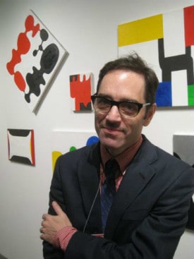 Eric Brown, director of Tibor de Nagy Gallery, photographed by Jill Krementz in New York on March 4, 2016, in front of paintings by gallery artist Andrew Masullo